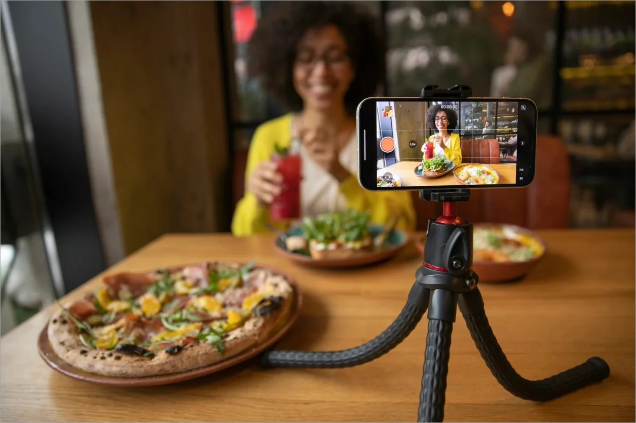The influencer takes pictures of food in a restaurant.