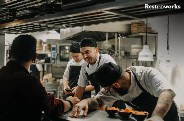 Restaurant staff talking in the kitchen.