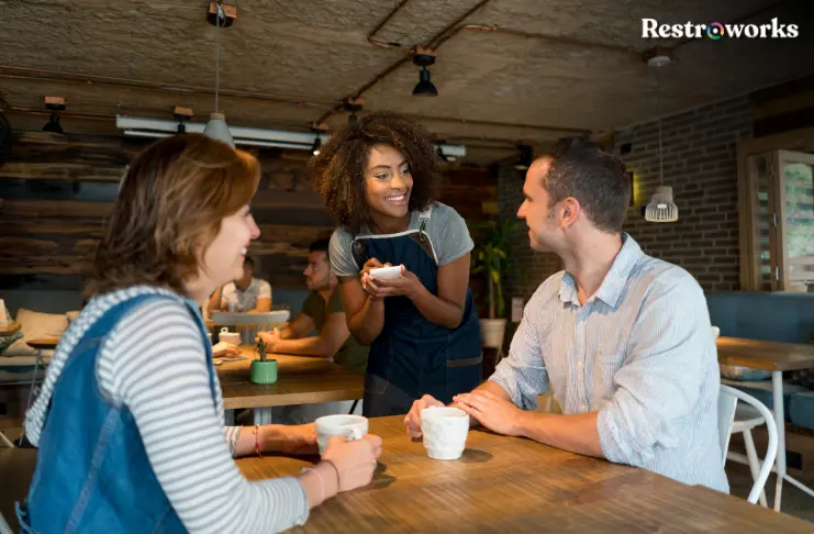 A restaurant staff taking interacting with customers.