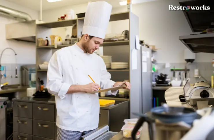 A restaurant chef taking inventory in the kitchen.